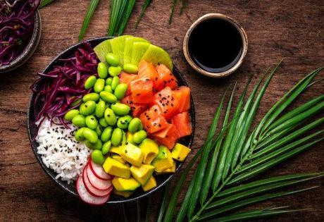 Poke bowl colorata con salmone, edamame e frutta.