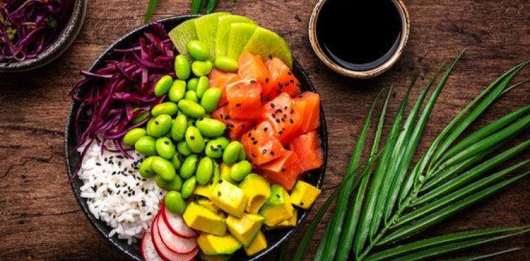 Poke bowl colorata con salmone, edamame e frutta.